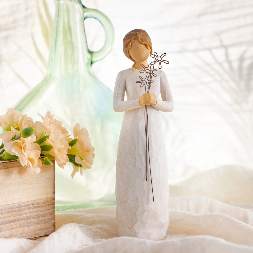 Willow Tree Grateful, 9”h hand-painted standing resin figure in cream dress, holding three wire flowers with long stems, on table with florals