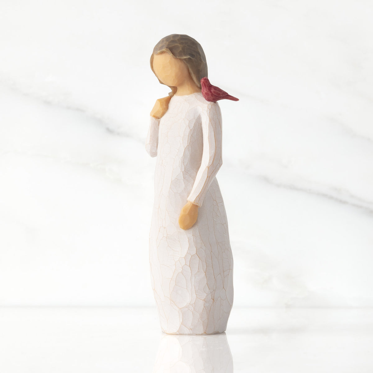 Front view of standing figure in cream dress with cardinal red bird perched on shoulder