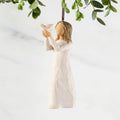 Figure in cream dress, holding white dove on extended arms. Hook and loop affixed to figure's head