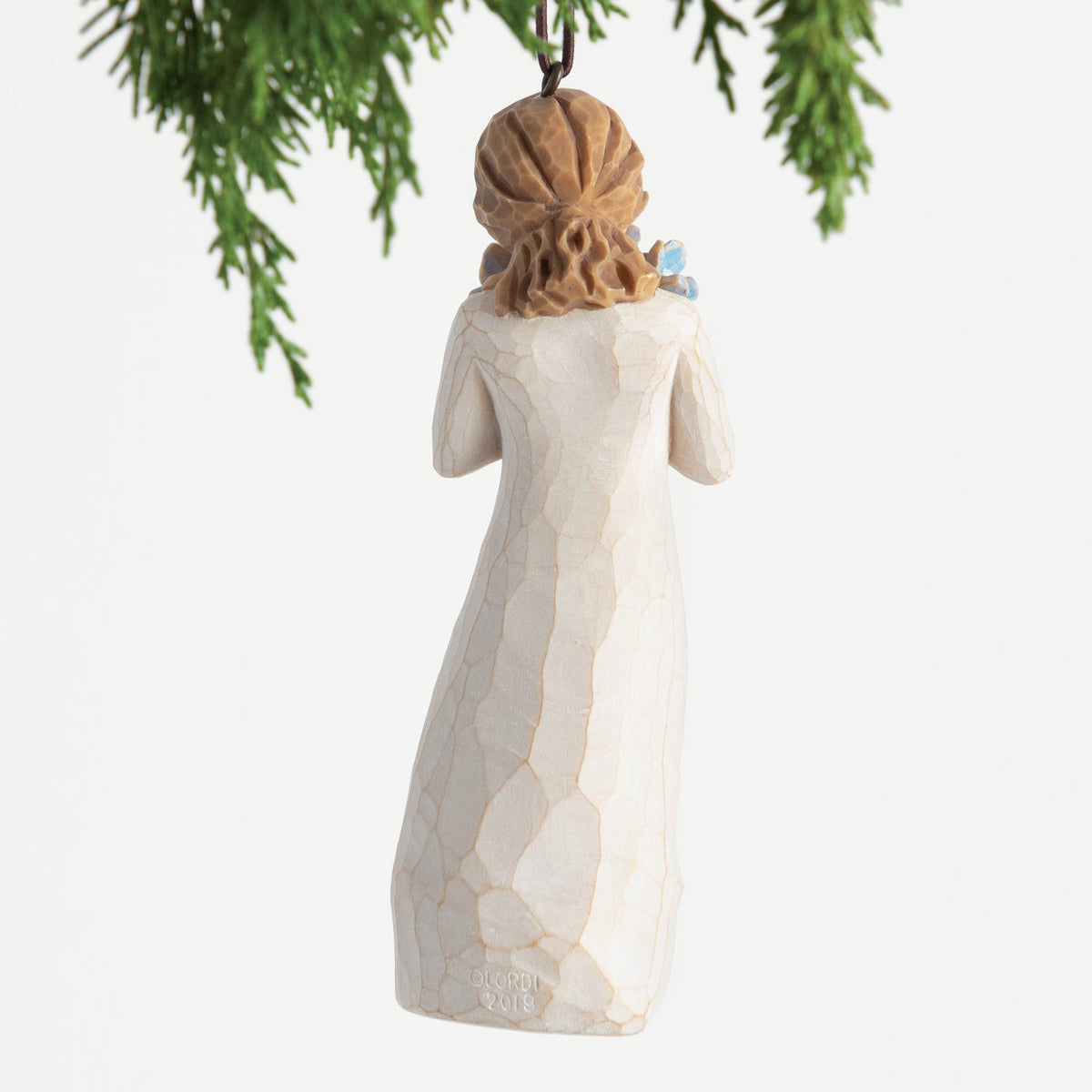 Back view, female figure in cream dress, holding bouquet of blue forget-me-not flowers to face. Hook and loop affixed to head