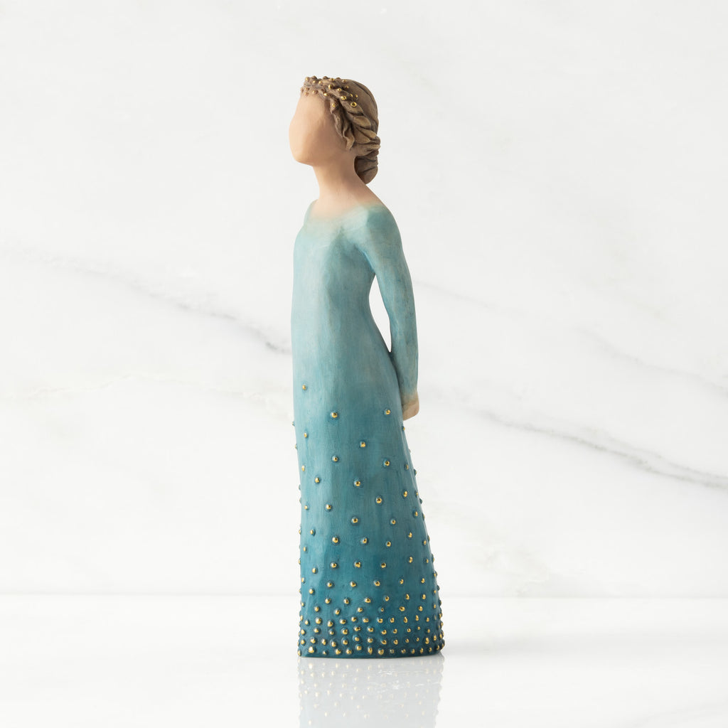 Facing left: Lighter-skin figure, arms clasped behind back, hair and deep blue ombré garment dotted with gold leaf
