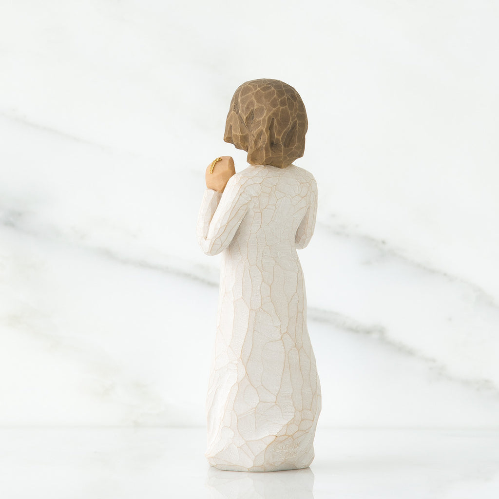 Back view of brunette girl figurine in white dress