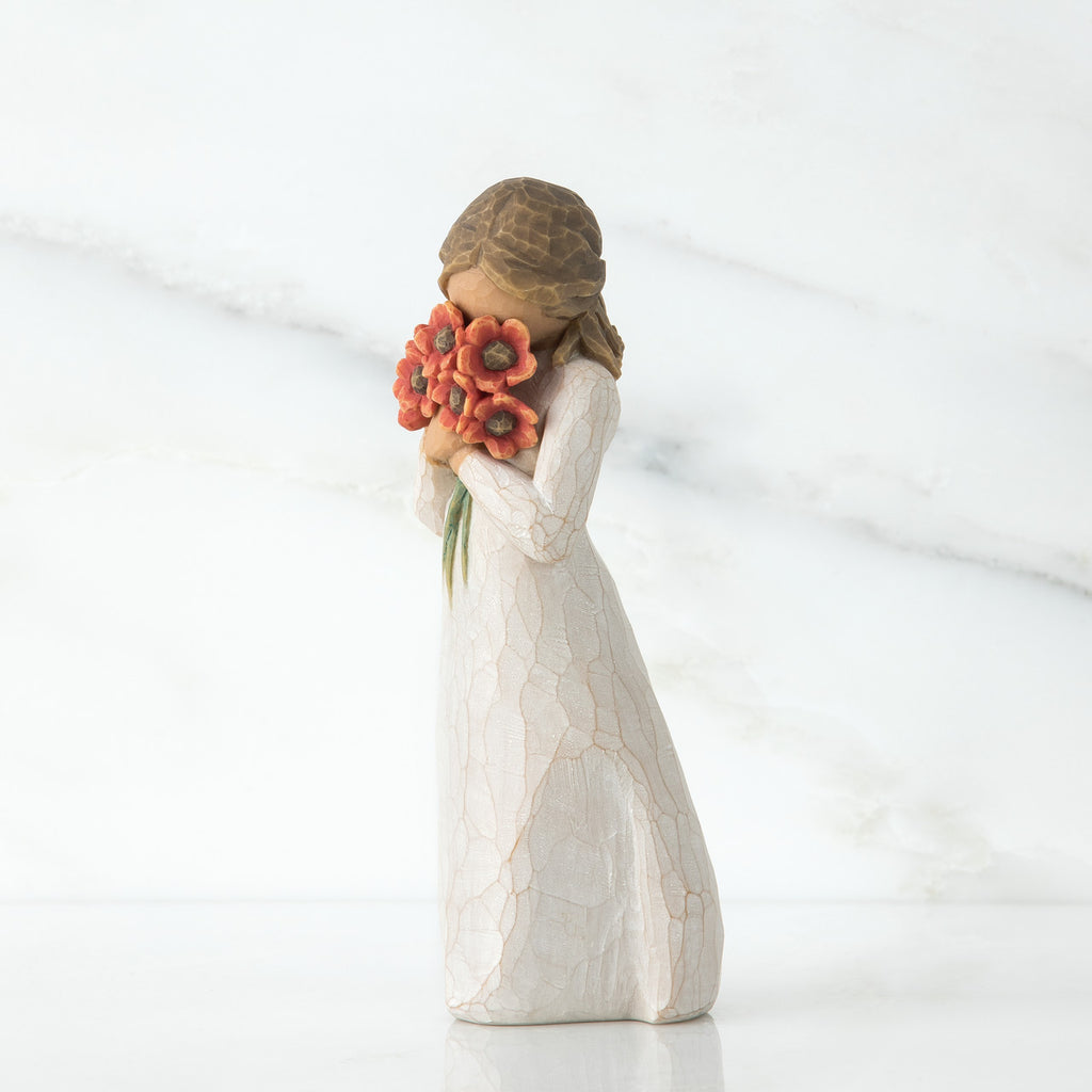 Brunette girl figurine in white dress holding orange flowers