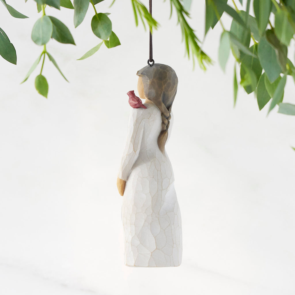 Left side of figure in cream dress with cardinal red bird perched on shoulder, hook & loop in head