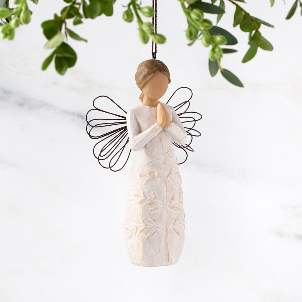 Female figure with wire wings in cream dress carved with a tree design, holding hands in prayer, ornament loop attached to head