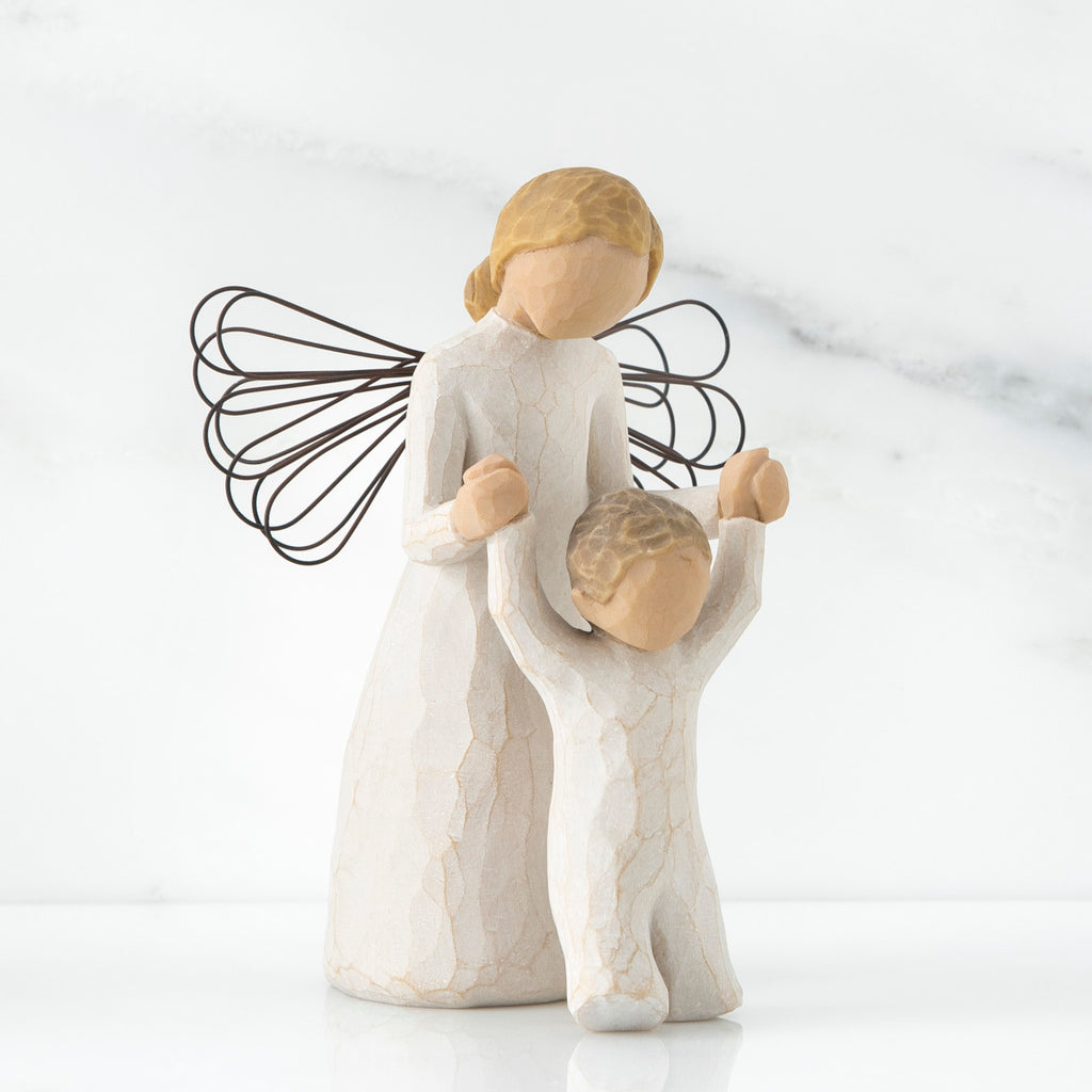 Mother faceless figurine with blonde hair wearing white dress and has black wire wings - holding baby standing on its feet